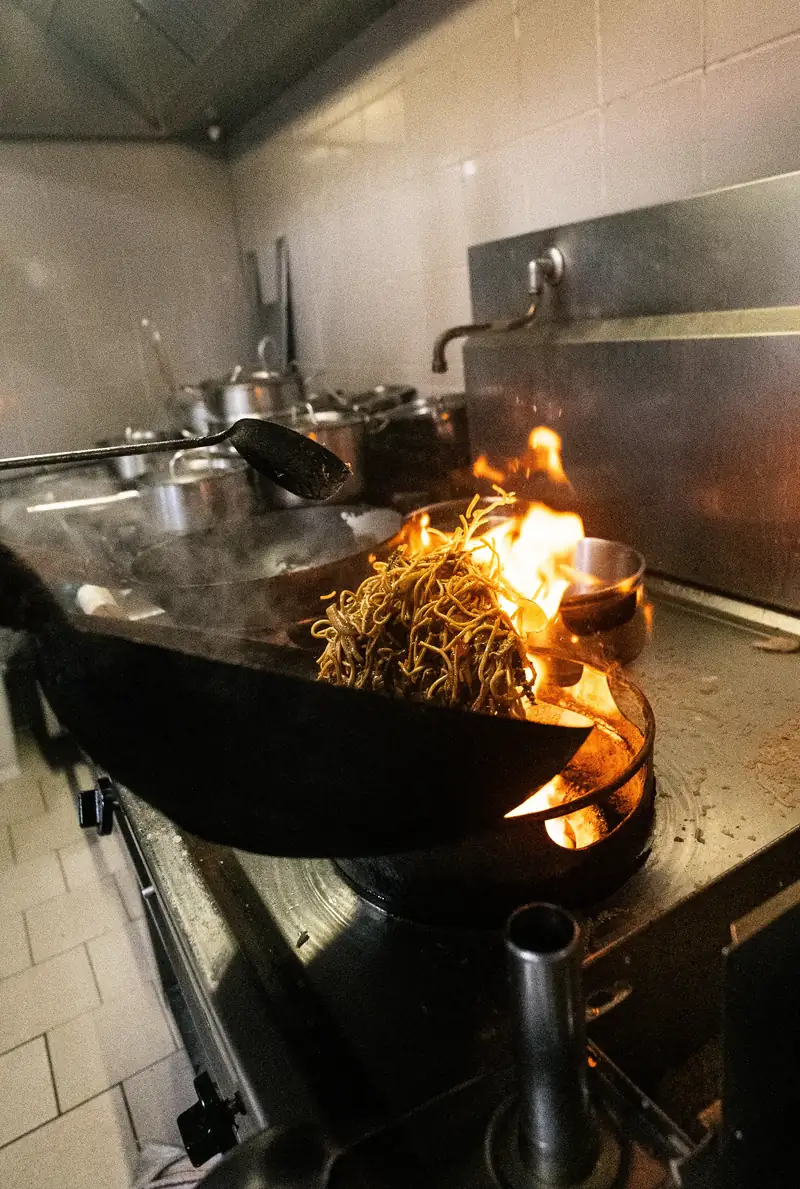 Wok en flammes dans la cuisine d'Influence Wok