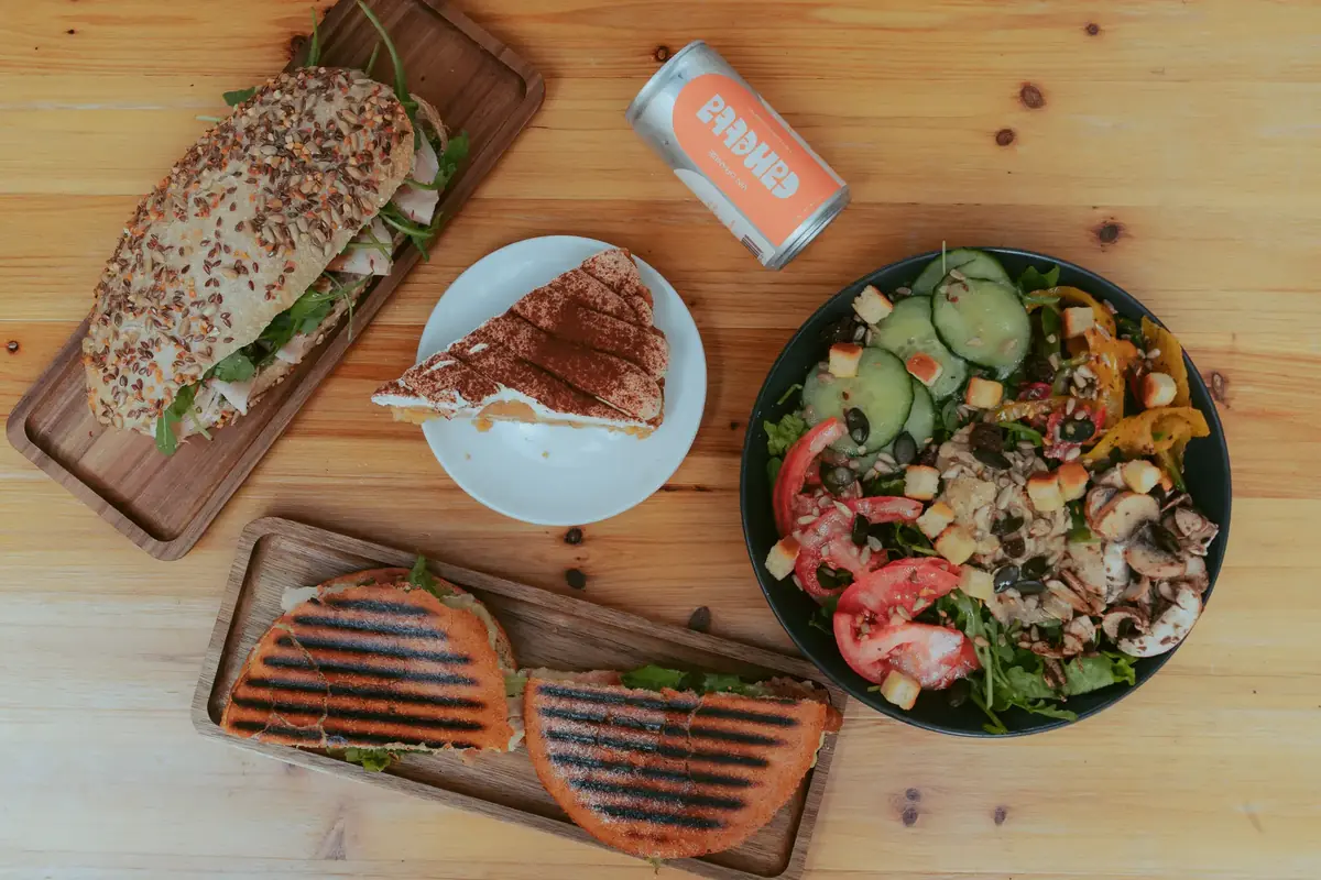 Sandwichs, salade composée et part de gâteau de Breadstorming sur une table en bois