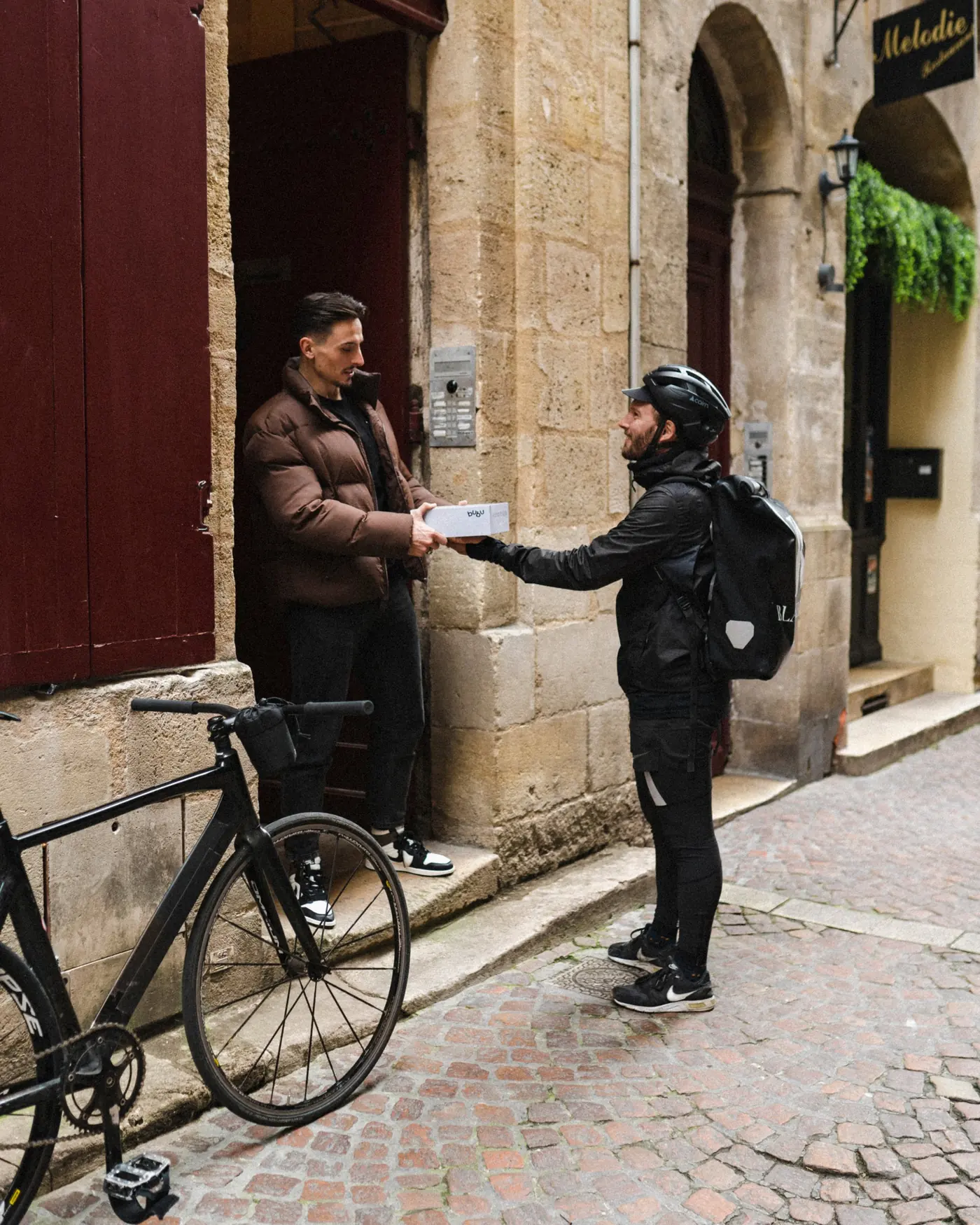 Un livreur Blackbird remet une commande à un client sur le pas de sa porte